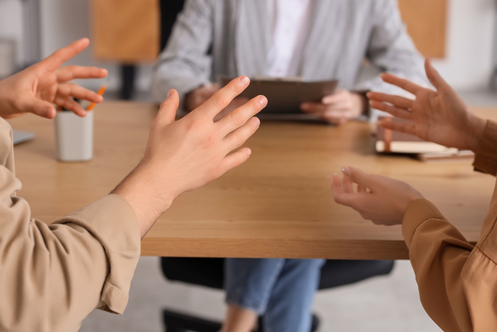 Couple discussing problems with family mediator at table in office